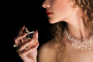 Vrouw spuit parfum op haar hals