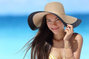 Vrouw met strandhoed tegen bescherming van de zon