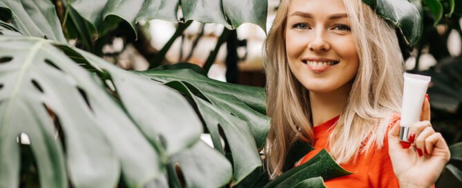 Mooie stralende vrouw met tube oogcrème