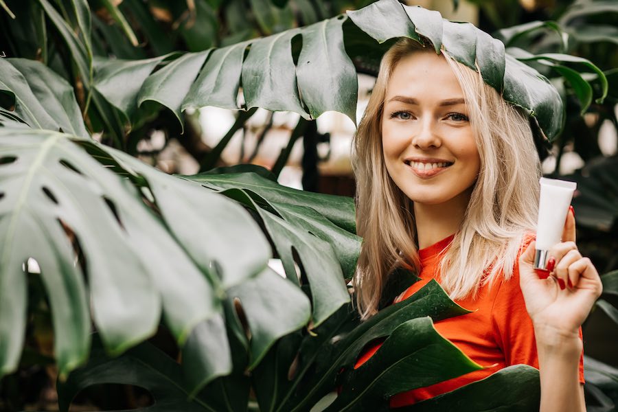 Mooie stralende vrouw met tube oogcrème